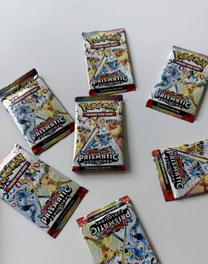 Pokémon Prismatic trading card game packs on a white surface