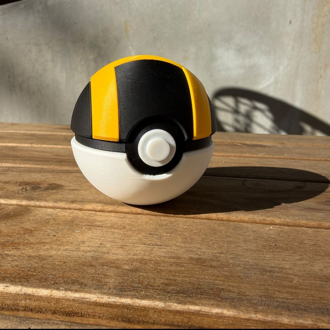Black and yellow Poké Ball-like object on a wooden surface with a concrete wall background